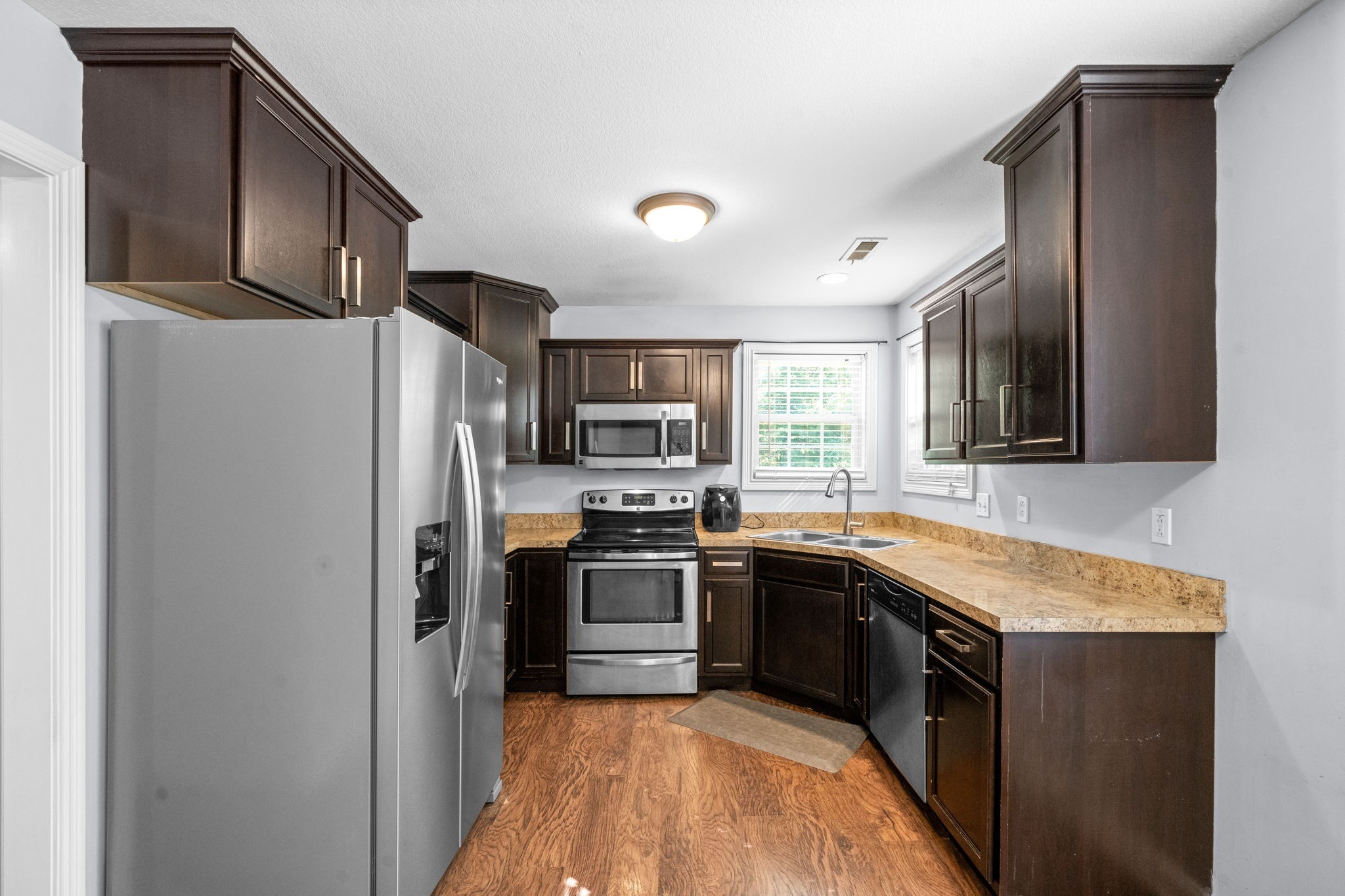 1148 York Meadows Road Clarksville, TN 37042 - Photo 13 of 35 a kitchen with stainless steel appliances granite countertop refrigerator a sink a stove top oven and a dishwasher with wooden floor