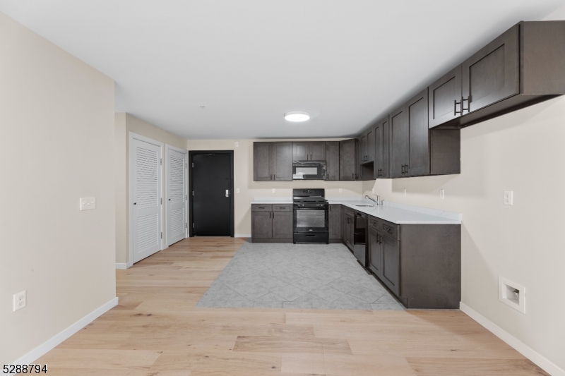 172 6th Street, Unit 54 Passaic, NJ 07055 - Photo 3 of 13 a large kitchen with a large counter top stainless steel appliances and cabinets