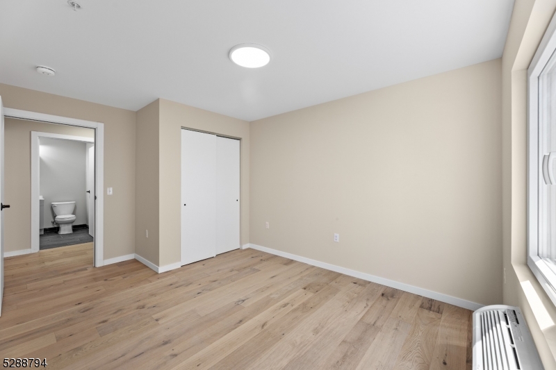 172 6th Street, Unit 54 Passaic, NJ 07055 - Photo 6 of 13 an empty room with wooden floor and a window