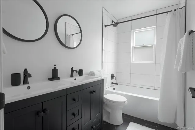 a bathroom with a double vanity sink toilet and shower