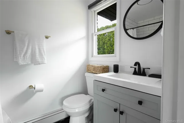 a bathroom with a toilet sink and mirror