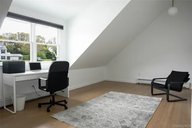 a view of a workspace with furniture and a window