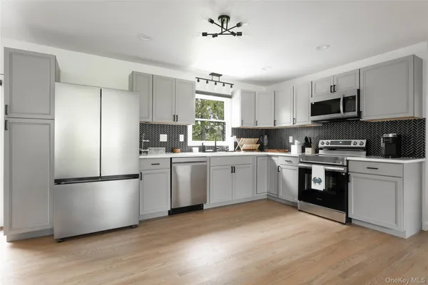 a kitchen with white cabinets stainless steel appliances and a window