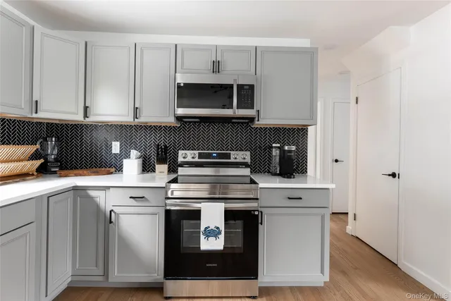 a kitchen with cabinets stainless steel appliances and wooden floor