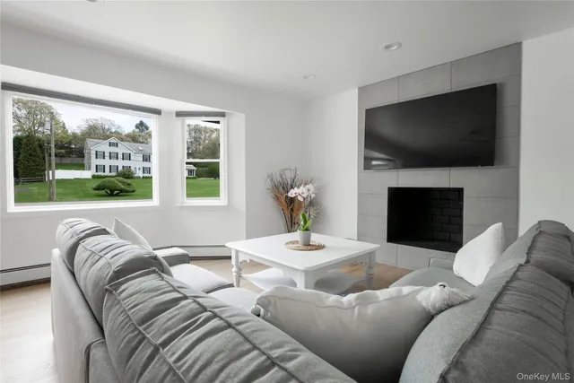 a living room with furniture a flat screen tv and a large window