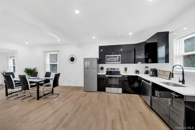 a large kitchen with stainless steel appliances kitchen island granite countertop a large center island and a wooden cabinets