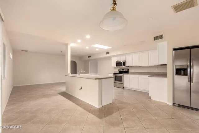 a large kitchen with white cabinets and stainless steel appliances