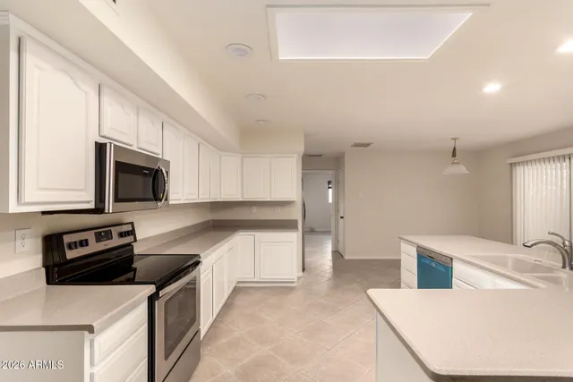 a kitchen with stainless steel appliances a stove a sink a microwave and a refrigerator