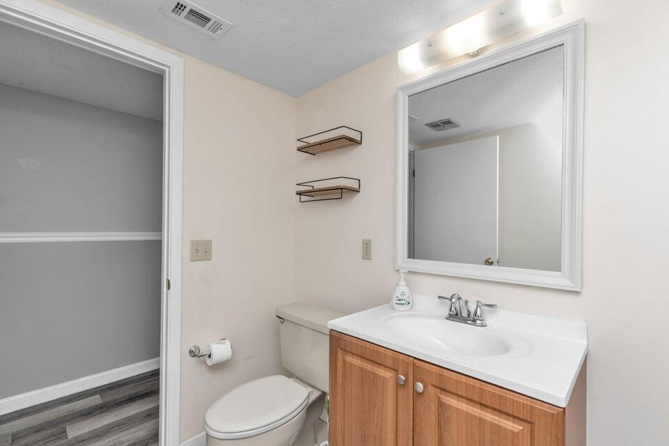 1037 4th Avenue Shalimar, FL 32579 - Photo 14 of 22 a bathroom with a toilet a sink a mirror and vanity