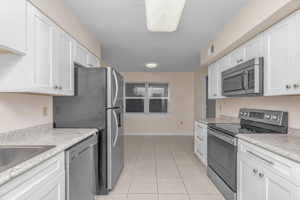 1037 4th Avenue Shalimar, FL 32579 - Photo 9 of 22 a kitchen with stainless steel appliances granite countertop a refrigerator sink and stove
