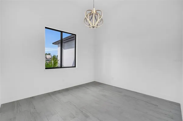 an empty room with windows and ceiling fan