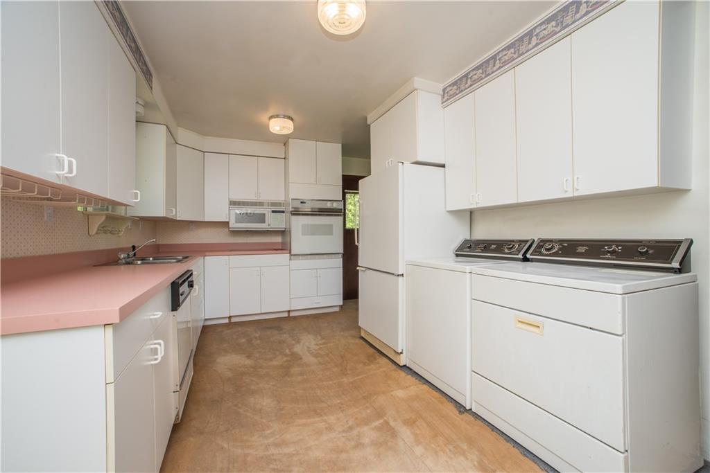 52 Cherry Valley Road McDonald, PA 15057 - Photo 22 of 25 The kitchen is found off the living room. It is equipped with wall oven, microwave, refrigerator, dishwasher, laundry facilities, and electric stove.