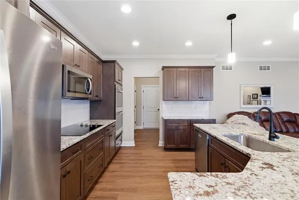 a kitchen with stainless steel appliances granite countertop a sink stove and refrigerator