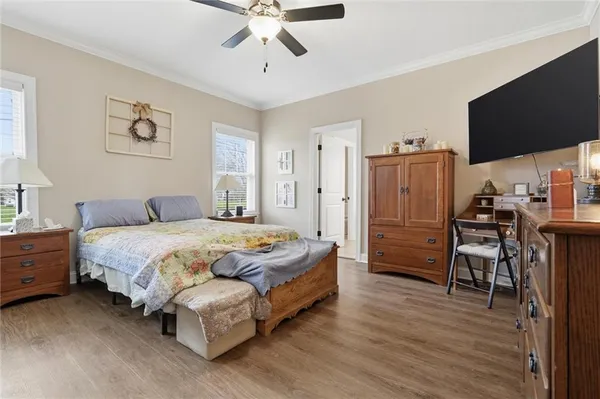 a spacious bedroom with a bed and a flat screen tv