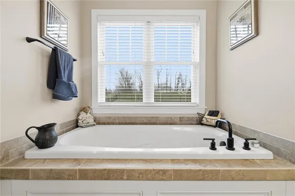 a bathroom with bathtub and window