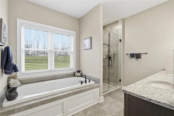 a bathroom with a granite countertop tub and a sink