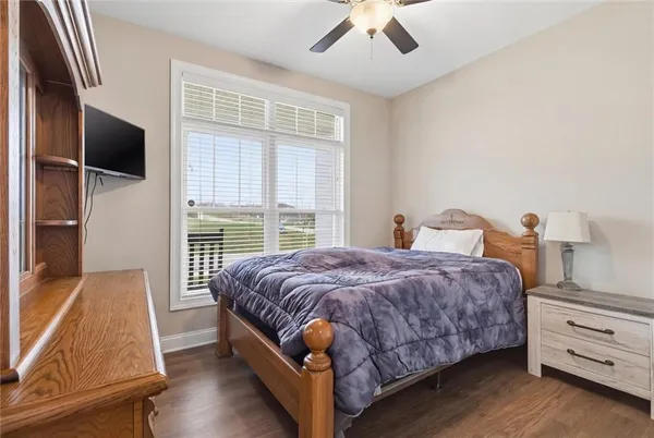 a spacious bedroom with a bed and wooden floor