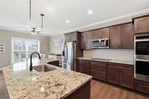 a kitchen with kitchen island granite countertop a stove microwave and refrigerator