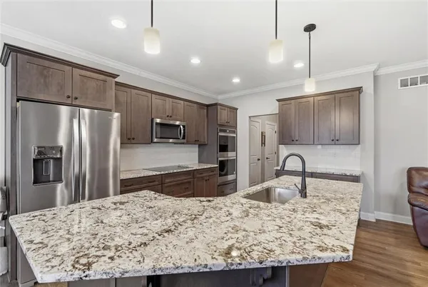 a kitchen with kitchen island a counter top space appliances and cabinets
