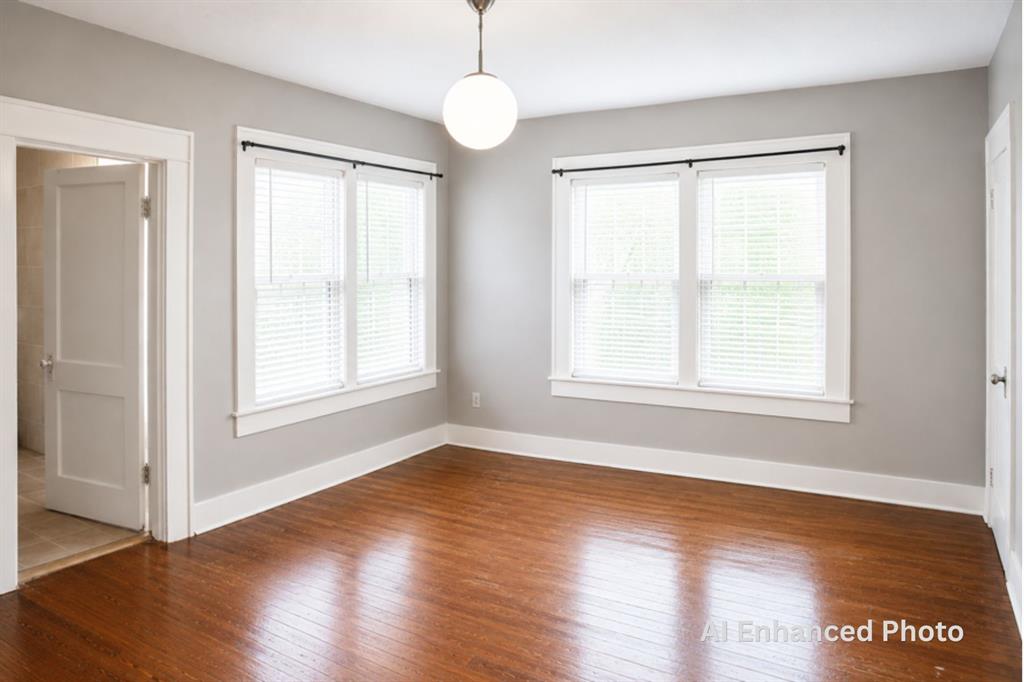 1500 Bonham Street Commerce, TX 75428 - Photo 12 of 29 a view of an empty room with wooden floor and a window