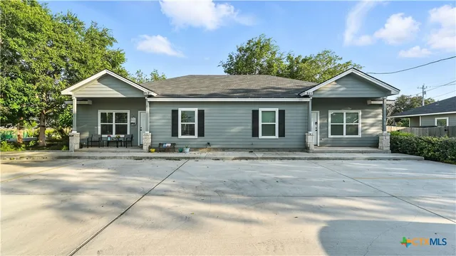 a front view of a house with a garden