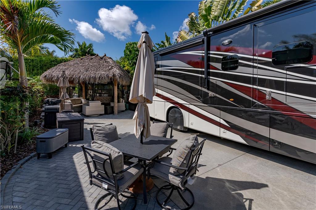 13580 Snook Circle Naples, FL 34114 - Photo 2 of 33 a view of a patio with a table and chairs and potted plants