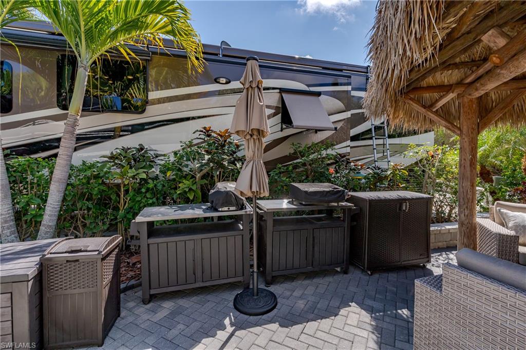13580 Snook Circle Naples, FL 34114 - Photo 9 of 33 a view of a patio with table and chairs a barbeque with wooden fence