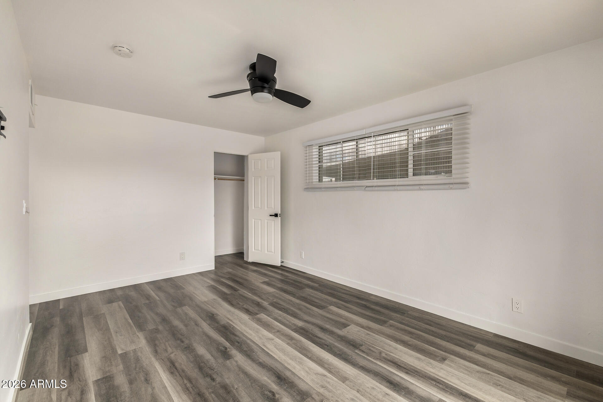 533 West 18th Street Tempe, AZ 85281 - Photo 23 of 52 a view of an empty room with wooden floor and a ceiling fan