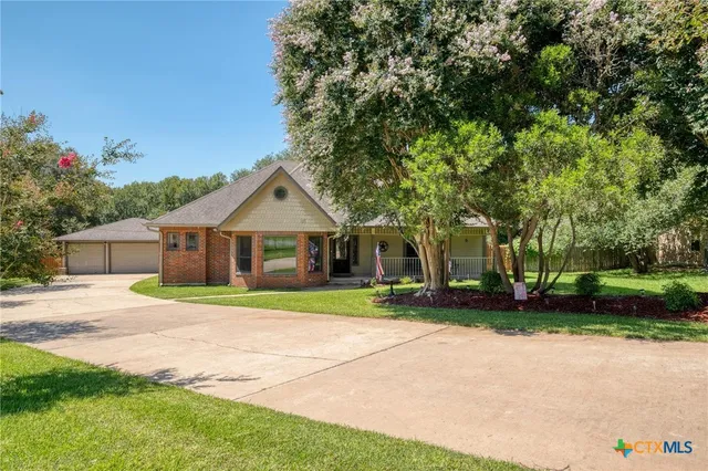 a front view of a house with a yard and trees