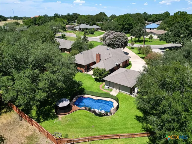 an aerial view of a house with yard swimming pool and outdoor seating