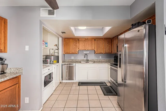 a kitchen with granite countertop a refrigerator sink and cabinets