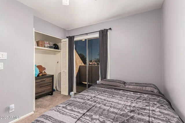 a bedroom with a bed and a flat tv screen on wall