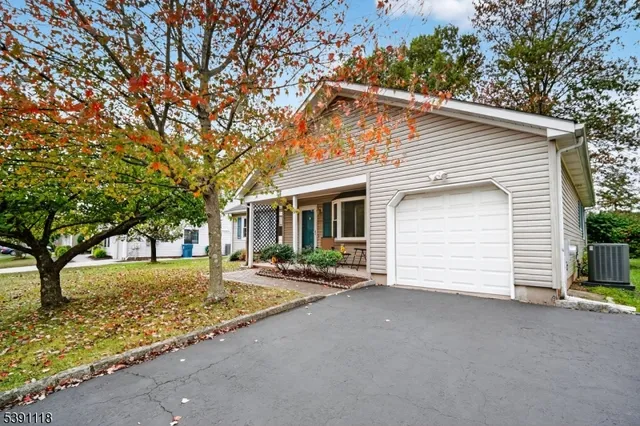 a front view of house with yard and trees in the background