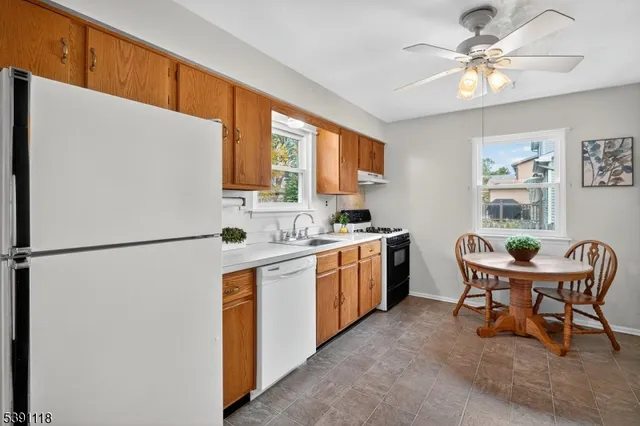 a kitchen with stainless steel appliances a refrigerator sink and white cabinets