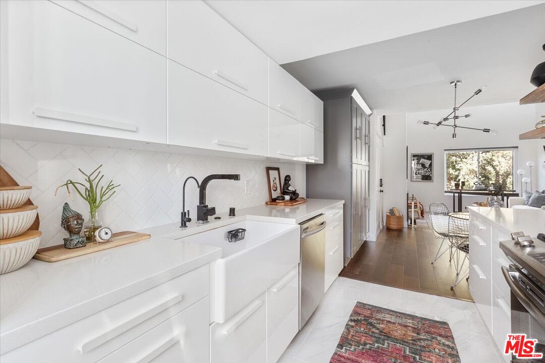 10960 Bluffside Drive, Unit 201 Studio City, CA 91604 - Photo 11 of 23 a large white kitchen with a sink and living room view