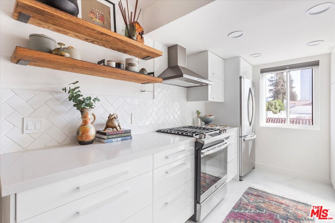 10960 Bluffside Drive, Unit 201 Studio City, CA 91604 - Photo 8 of 23 a kitchen with stainless steel appliances granite countertop a sink and a stove