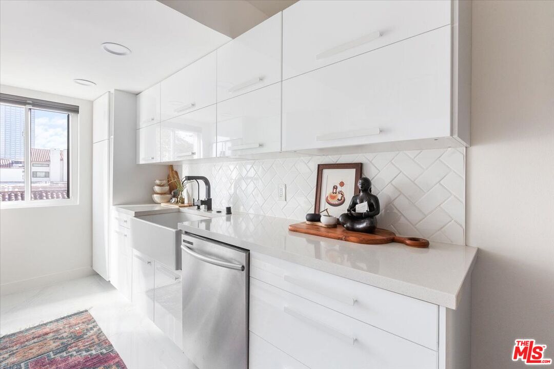 10960 Bluffside Drive, Unit 201 Studio City, CA 91604 - Photo 9 of 23 a kitchen with stainless steel appliances a sink a stove and white cabinets