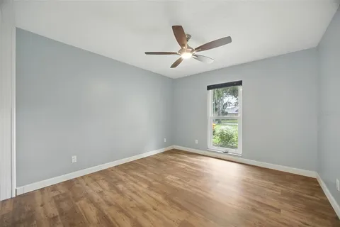an empty room with closet and a chandelier fan