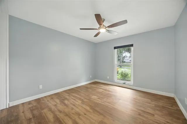 an empty room with closet and a chandelier fan