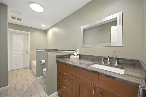 a bathroom with a granite countertop sink mirror and shower