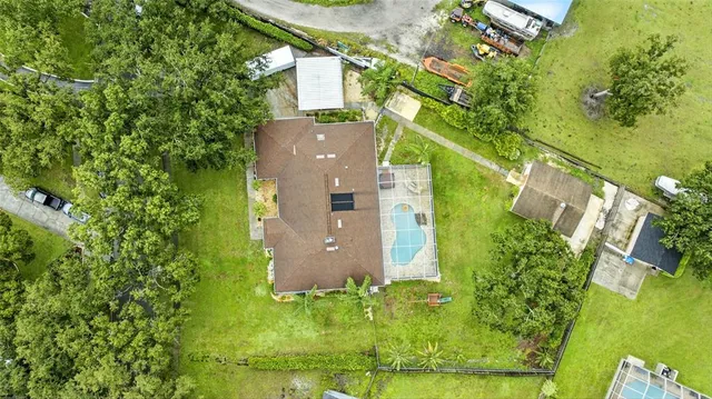 an aerial view of residential houses with outdoor space and trees