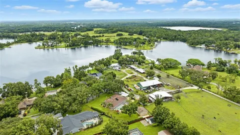 an aerial view of residential houses with outdoor space and river