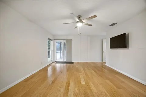 a view of an empty room with a flat screen tv and a window