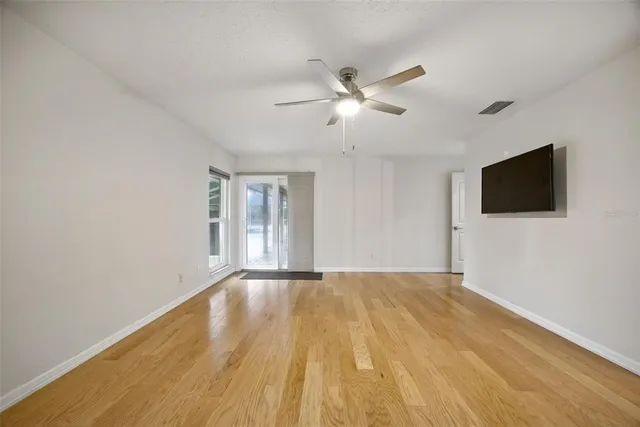 a view of an empty room with a flat screen tv and a window