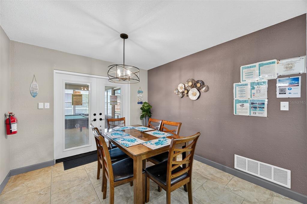 1576 Rosery Road Northeast Largo, FL 33756 - Photo 18 of 54 a dining room with furniture a chandelier and wooden floor