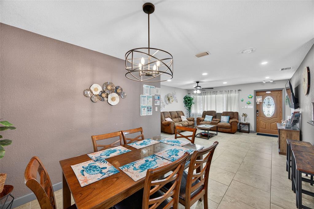 1576 Rosery Road Northeast Largo, FL 33756 - Photo 19 of 54 a view of a dining room and livingroom with furniture a rug a rug and a chandelier