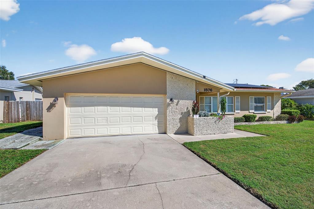 1576 Rosery Road Northeast Largo, FL 33756 - Photo 2 of 54 a front view of a house with a yard and garage