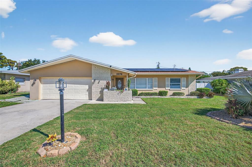 1576 Rosery Road Northeast Largo, FL 33756 - Photo 3 of 54 a front view of a house with a yard