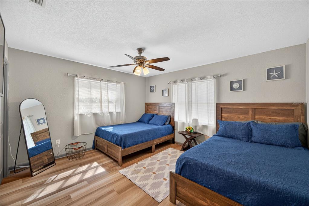 1576 Rosery Road Northeast Largo, FL 33756 - Photo 32 of 54 a bedroom with two beds and painting on the wall