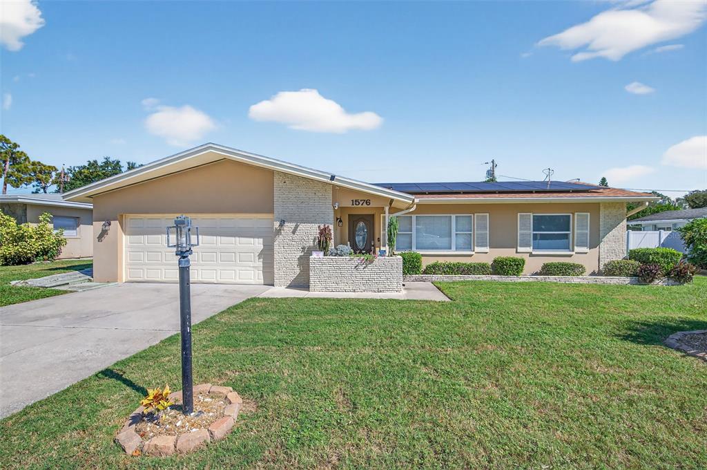 1576 Rosery Road Northeast Largo, FL 33756 - Photo 4 of 54 a front view of a house with a yard